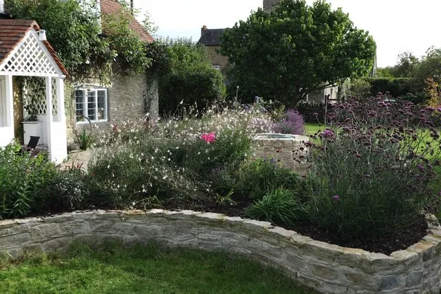 A raised stone border planted with perennials
